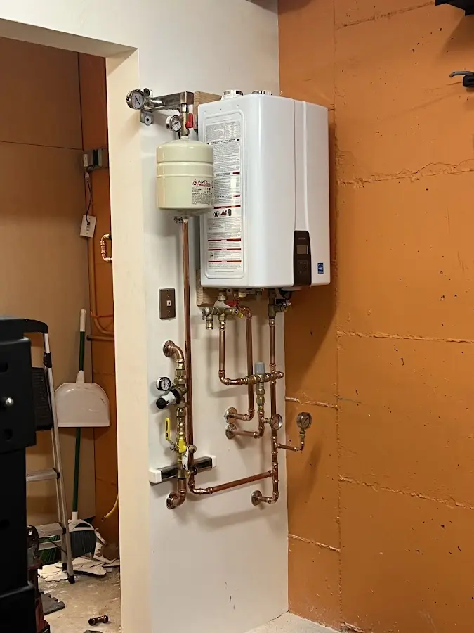 Plumbing technician inspecting water heater connections in Hartsville